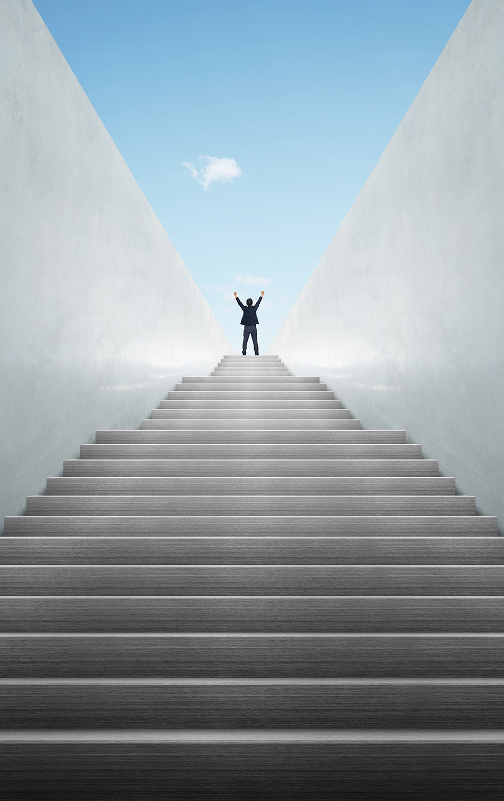 Mann steht jubelnd oben auf einer Treppe